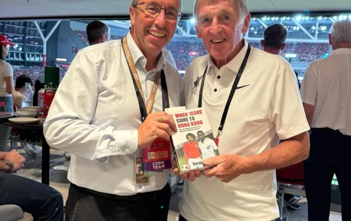 At Kai Tak Stadium, as Liverpool FC play AC Milan: stadium CEO John Sharkey presents Sir Kenny Dalglish with a copy of "When ‘Jesus’ Came to Hong Kong", Derek Currie's book about being the first European football star to play in Asia